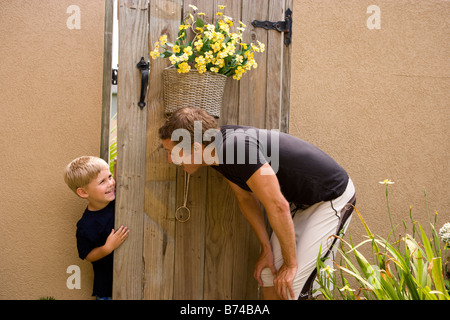 Little boy peeking through wooden door at father Stock Photo