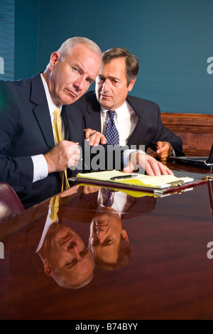Two corporate executives in boardroom with serious and worried expression Stock Photo