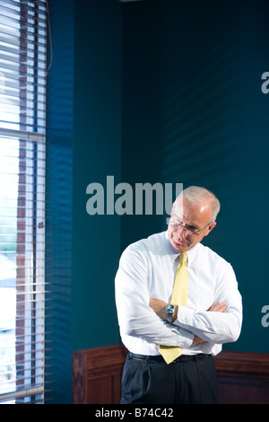 Businessman standing next to window Stock Photo