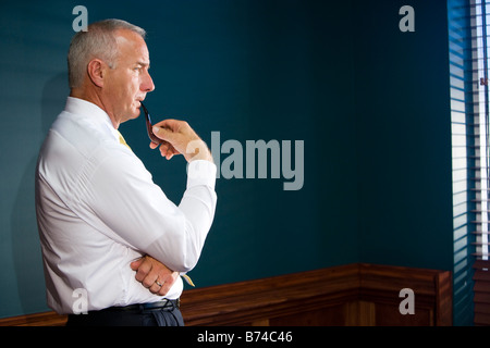Profile of businessman standing inside near window Stock Photo