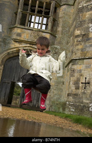 Little Boy Jumping in a Puddle Stock Photo