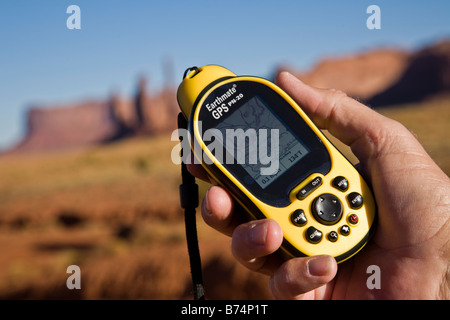 Global positioning satellite (GPS) unit being held in a mans hand Monument Valley, Arizona, USA Stock Photo