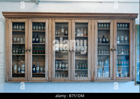 Timber cabinet containing jars of dyes and chemicals used in the wool making process Stock Photo