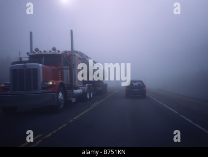 tanker truck, 18 wheeler, semi, travelling in fog on a highway Stock Photo