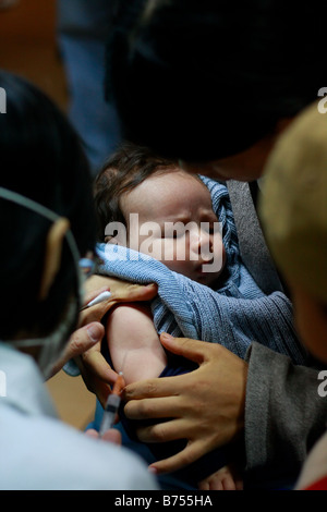 Young newborn Asian Caucasian baby boy recieve immunization shots in Guangzhou Guangdong China He is clearly surprised and not h Stock Photo