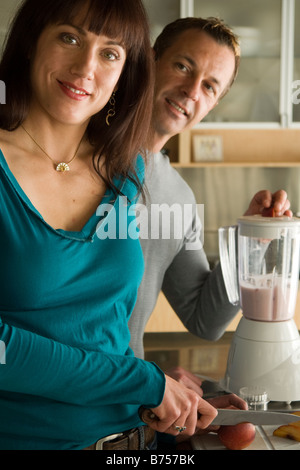 Couple making fruit smoothies with organic fruit, Winnipeg, Canada. Stock Photo