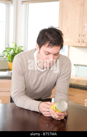 Man reading nutritional information labeling on can, Winnipeg, Canada Stock Photo
