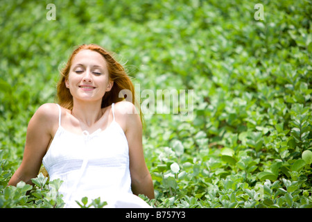Young woman sitting on meadow Stock Photo