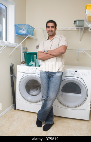 Man stands beside energy and water efficient front loading washing machine, Winnipeg, Canada Stock Photo