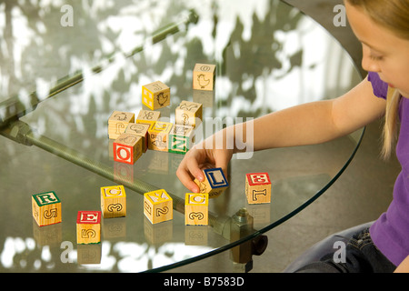 Young girl spelling recycle with alphabet blocks Stock Photo