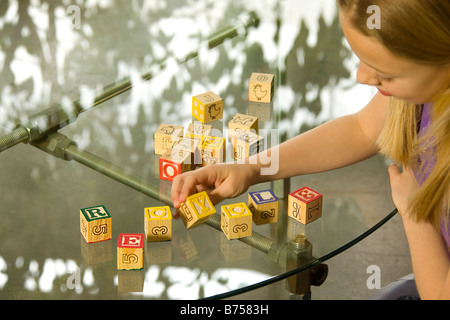 Young girl spelling recycle with alphabet blocks Stock Photo