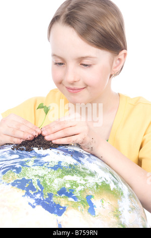 9 year old girl with the small plant on the globe, Winnipeg, Manitoba Stock Photo