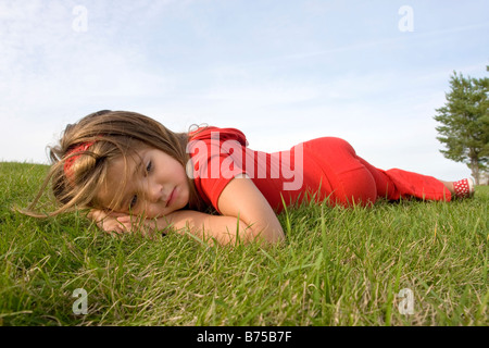 Six year old girl laying on grass, Winnipeg, Manitoba, Canada Stock Photo