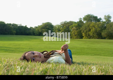 Eight year old girl laying down on grass in park, Winnipeg, Canada Stock Photo