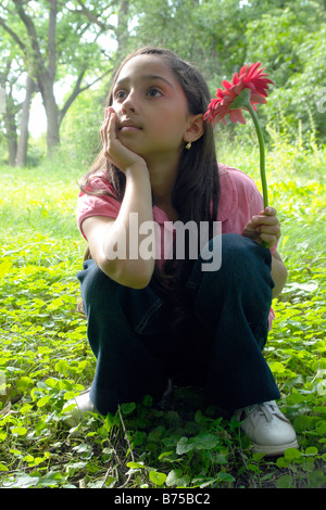 Eight year old girl in clearing with flower, Winnipeg, Canada Stock Photo