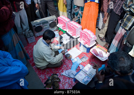 Men gathered around a vendor selling medicine in Dhaka Bangladesh Stock Photo