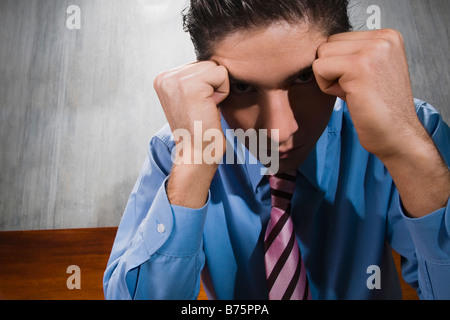 Close-up of a businessman sitting on a bench with his head in his hands Stock Photo