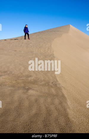 A hiker stands on a sand dune above the White Bluffs of the Hanford Reach along the Columbia River Washington Stock Photo