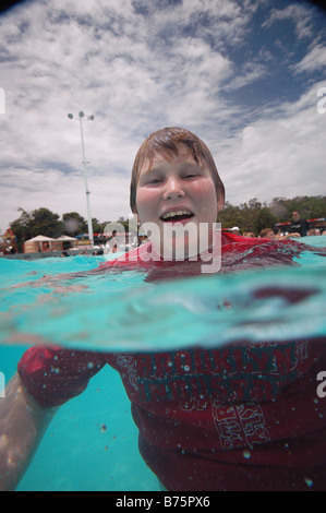 young boy floating in swimming pool Stock Photo