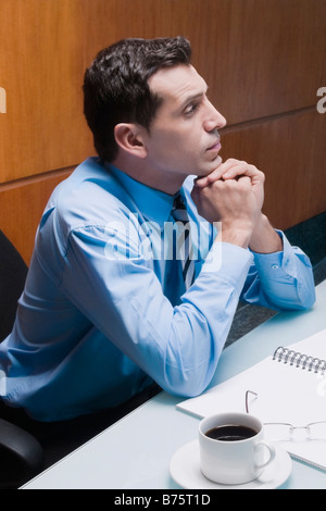 Businessman sitting in an office chair and thinking Stock Photo