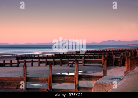 wooden groynes on barmouth beach at sunset Stock Photo