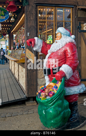 Plastic Father Christmas stands besides a stall at the Winter Wonderland at Hyde Park London, England UK Stock Photo