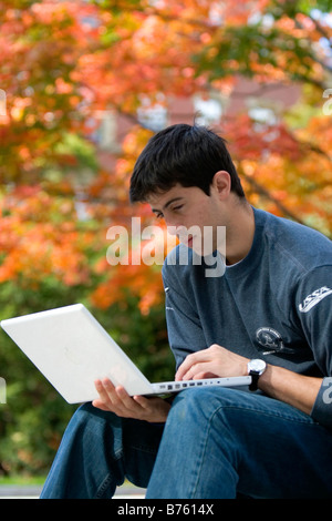 Male student studying with a laptop computer in Harvard Yard at Harvard University in Cambridge Greater Boston Massachusetts USA Stock Photo
