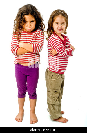 two little girls back to back in quarrel isolated on white Stock Photo