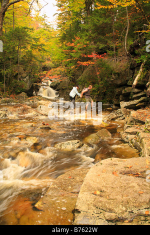 Hikers Cross Cascade Brook on Cascades-Basin Trail, Appalachain Trail, Lincoln, New Hampshire, USA Stock Photo