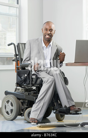 Businessman with Cerebral Palsy working on a computer with his foot Stock Photo