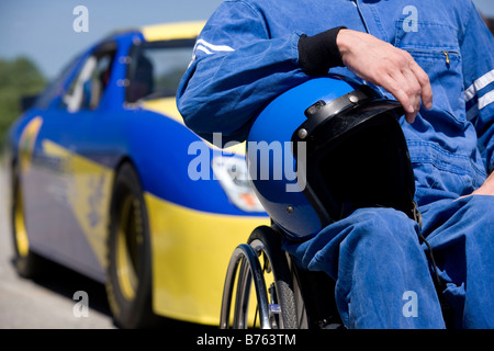 Disability race car driver, mid section, car in background Stock Photo