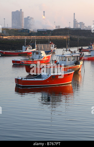 Redcar steelworks with small inshore fishing boats at Paddys Hole inlet on the River Tees at Teesmouth on the South Gare Stock Photo