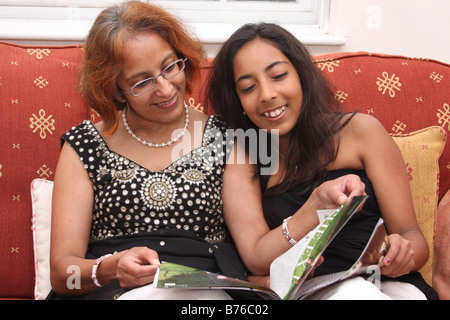 A mother and teenager daughter reading a magazine. Stock Photo