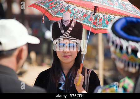 A Hmong girl wearing sunglasses, with reflections of other participants, during a Hmong New Year Ceremony Ball tossing game Stock Photo