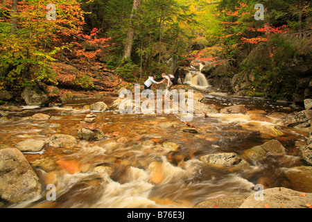 Hikers Cross Cascade Brook on Cascades-Basin Trail, Appalachain Trail, Lincoln, New Hampshire, USA Stock Photo