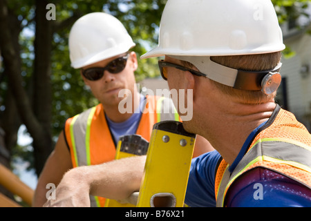 Two workers talking on construction site Stock Photo