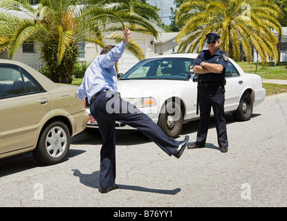 Motorist trying to walk a straight line while a police officer looks on Stock Photo