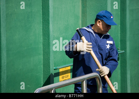 Star Ferry man in uniform helping to berth ferry, Tsim Sha Tsui, Kowloon Peninsula, Hong Kong, People's Republic of China Stock Photo