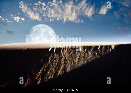 A larger than life depiction of the full moon rising above a sand dune at White Sands National Monument, New Mexico. Stock Photo