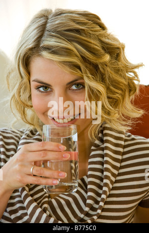 Junge Frau trinkt Mineralwasser, Young woman drinks mineral water Stock Photo