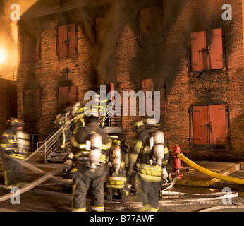 Firefighters burning building Stock Photo