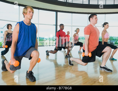 Fitness class doing lunges dumbbells Stock Photo