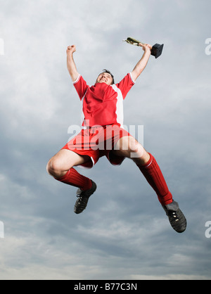 Soccer player jumping mid-air trophy Stock Photo