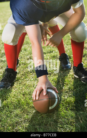 Football center preparing to snap football Stock Photo