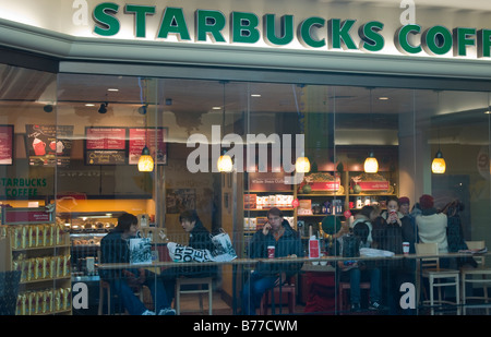 Starbucks Coffee shop inside a shopping mall photographed through the window with the sign prominent at the top Stock Photo