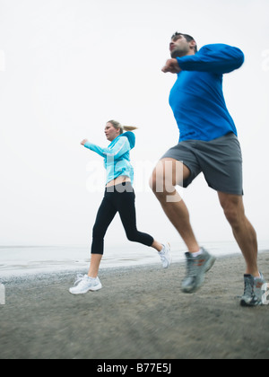 Couple jogging on beach Stock Photo