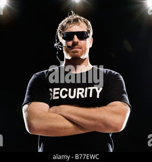 Security guard headset posing arms crossed Stock Photo