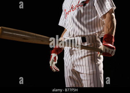 Baseball player holding bat Stock Photo