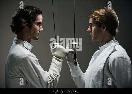 Fencers facing off fencing foils Stock Photo