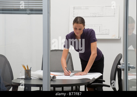 Architect working on blueprints office Stock Photo